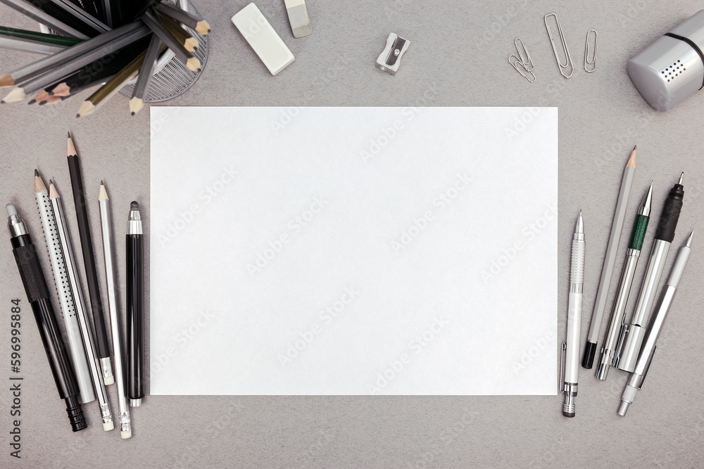 office workspace with blank paper sheet and various drawing tools, top