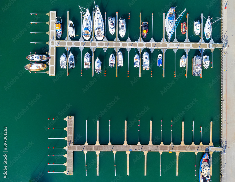Aerial view of amazing boats at sunset. Minimalist landscape with boats and sea in marina bay. Drone view of the harbor with yacht, powerboat and sailboat. Beautiful port of Poland Gdynia.