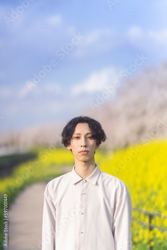 花が咲き誇る公園に立っている若者のポートレート