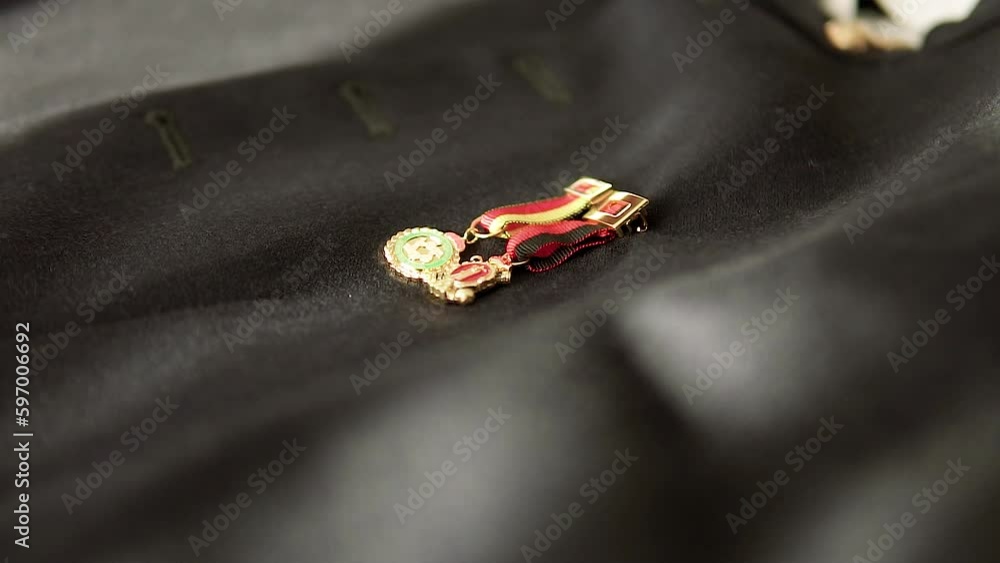Close-up of two small insignia Spanish medals on the groom's black military jacket Close-up of two small insignia Spanish medals on the groom's black military jacket