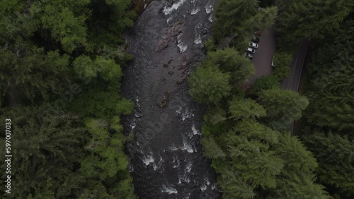 Aerial drone view of river rushing through a green forest in Southwest Washington State