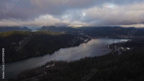 Ocean inlet next to mountains with cities along the shore during a cloudy evening in Vancouver, BC