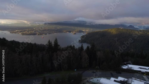 Ocean bay next to mountains with towns along the shore in Vancouver BC on a cloudy evening