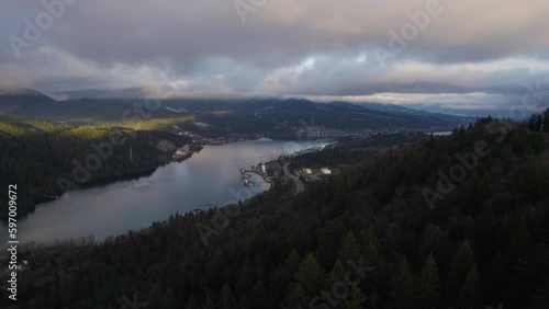 Ocean bay next to mountains with cities along the shore in Vancouver BC on a cloudy sunset