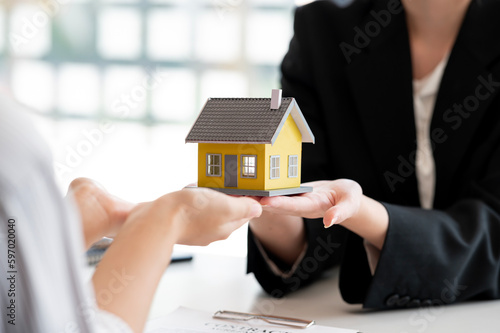 Close-up shot of a real estate agent or realtor meeting with her client, giving new house to her customer..