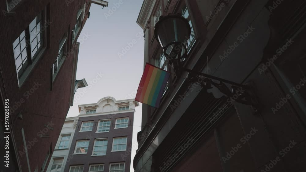 LGBT LGBTQ+ Rainbow Pride Flag at Small Narrow Street Alley Amsterdam, Netherlands LGBT LGBTQ+ Rainbow Pride Flag at Small Narrow Street Alley Amsterdam, Netherlands