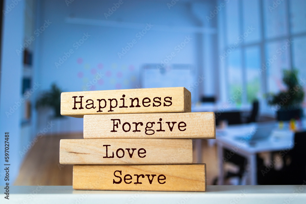 Wooden blocks with words 'Happiness, Forgive, Love, and Serve'.