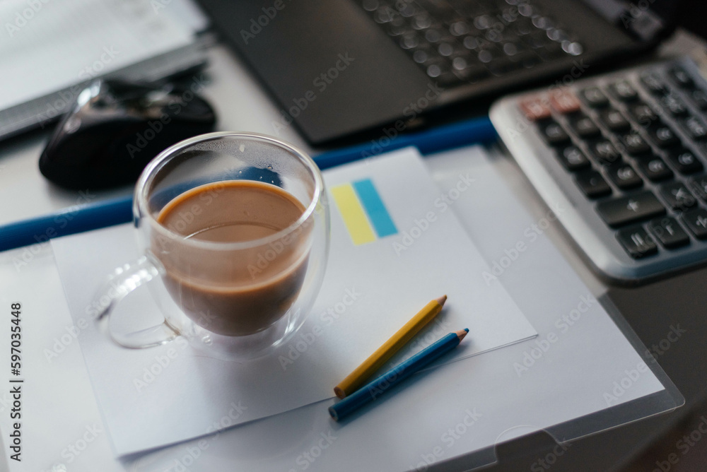 Ukrainian workplace. With Ukraine in mind. Morning cup of coffee at the workplace with a laptop. Ukrainian workplace. With Ukraine in mind. Morning cup of coffee at the workplace with a laptop.