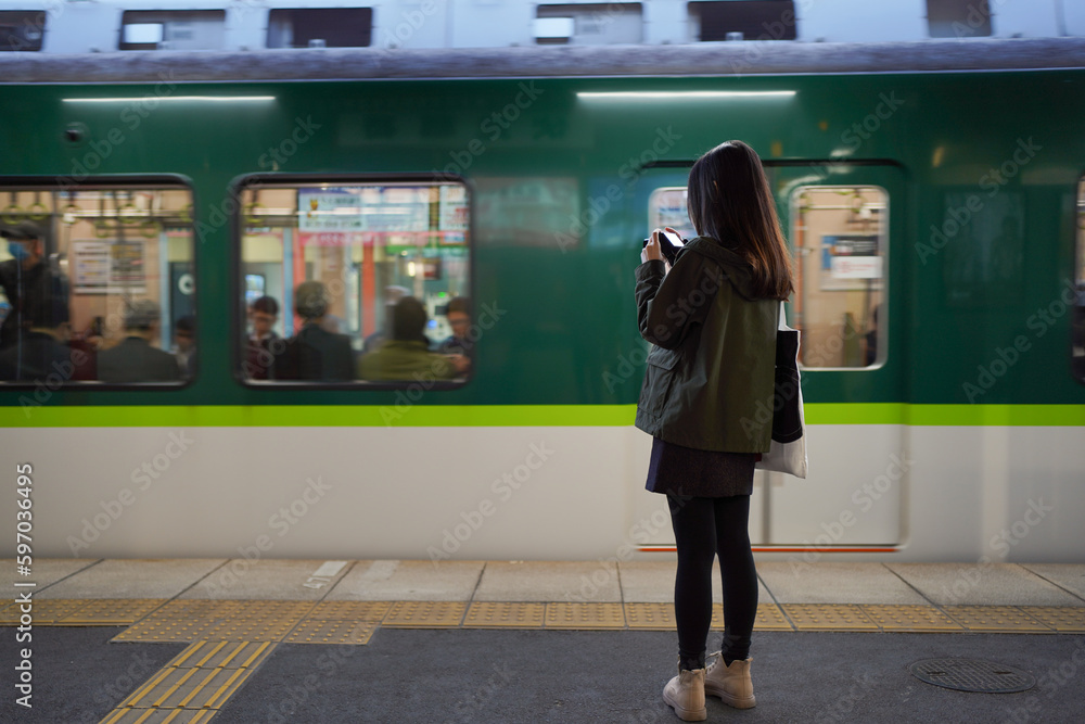 Asian young ladies taking photo of the train arrival at railway station. Travel concept. Asian young ladies taking photo of the train arrival at railway station. Travel concept.