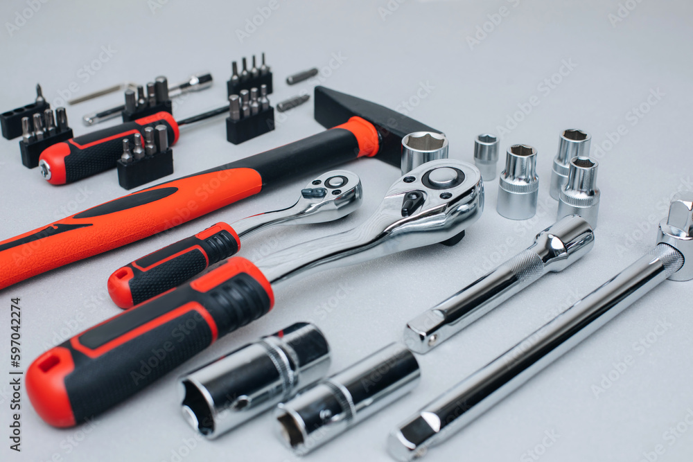 Fototapeta premium A set of working tools, a hammer, a screwdriver, sockets for an answer on a gray concrete background. Front view
