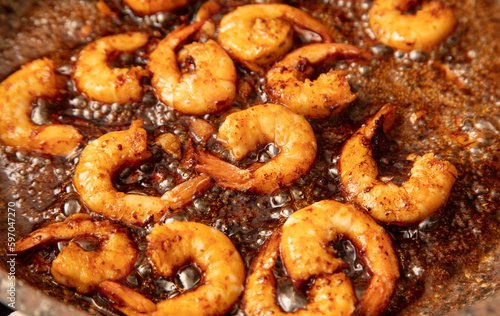 Shrimps are fried in oil in a frying pan