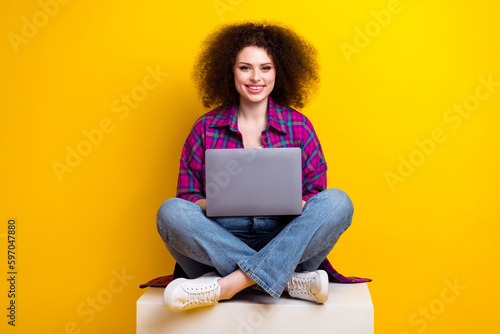 Full length photo of charming pretty woman dressed plaid shirt working modern device isolated yellow color background