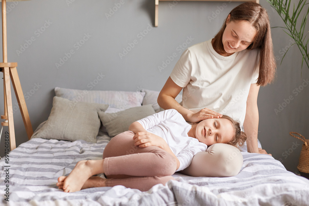 Mother and little daughter child relaxing laying on bed at home in bedroom, sleeping indoors, family generations enjoying time together, vacation leisure loving care child falling asleep. Mother and little daughter child relaxing laying on bed at home in bedroom, sleeping indoors, family generations enjoying time together, vacation leisure loving care child falling asleep.