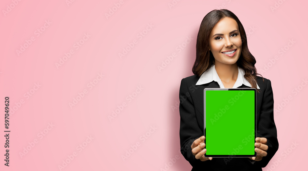 Portrait of happy smiling brunette businesswoman showing tablet pc, touchpad, with green chroma key screen, on rose pink background. Confident attractive business woman at office. Portrait of happy smiling brunette businesswoman showing tablet pc, touchpad, with green chroma key screen, on rose pink background. Confident attractive business woman at office.