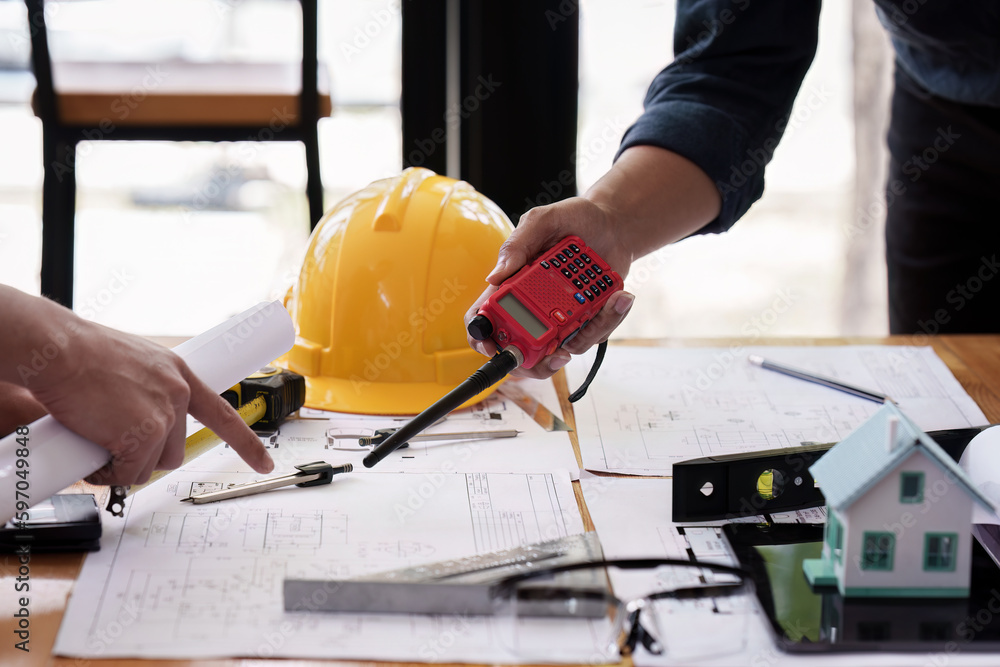 Architect and Engineer working with blueprints for architectural plan, engineer sketching a construction project, green energy concept Architect and Engineer working with blueprints for architectural plan, engineer sketching a construction project, green energy concept