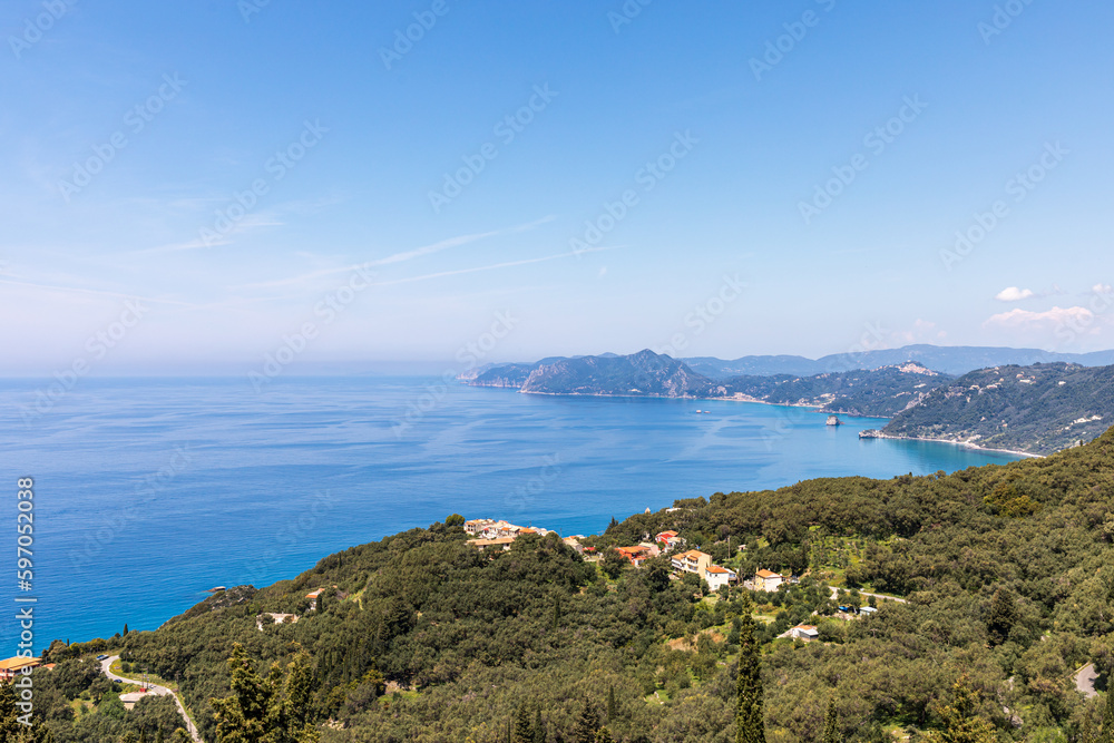 A beautiful landscape of the coast of the island of Corfu in the Ionian Sea of the Mediterranean in Greece. Pure blue clear water washes over the shores of the Greek island.