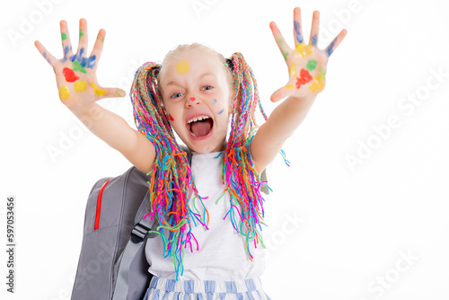Adorable blonde preschooler kid with colorful pigails showing dirty hands with colors at camera laughing screaming delightfully is ready to go to school after holidays.