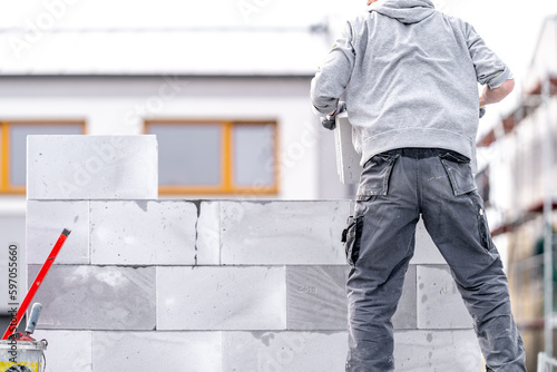 Foto a mason builds the wall of a building from concrete bricks and blocks