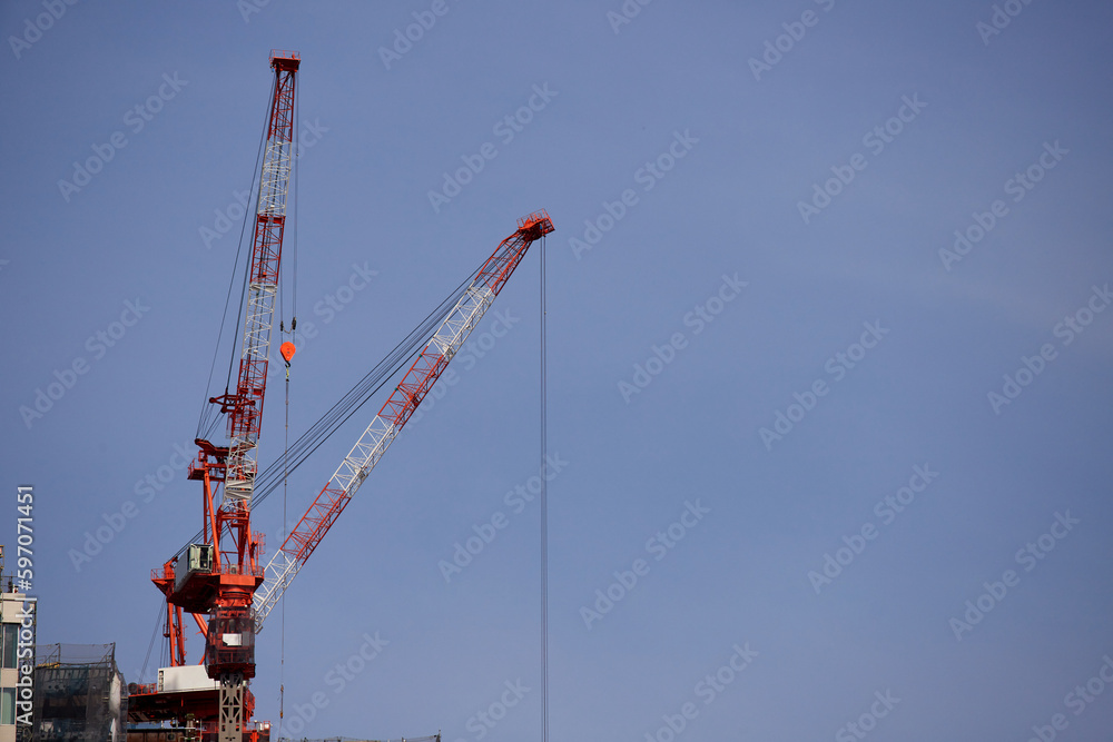 高層ビルの建設現場の高いクレーンの風景