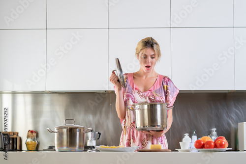 Excited surpised woman in the kitchen in the morning and cooking healthy food. Sensual housewife. photo