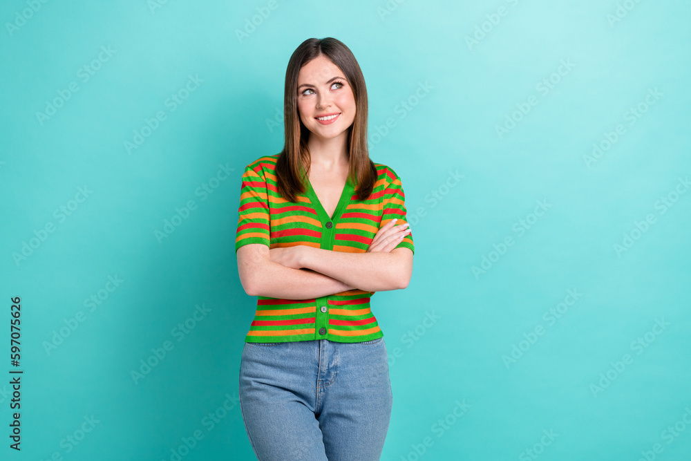 Photo of stunning cute cheerful lady wear trendy clothes arms crossed interested look empty space isolated on cyan color background