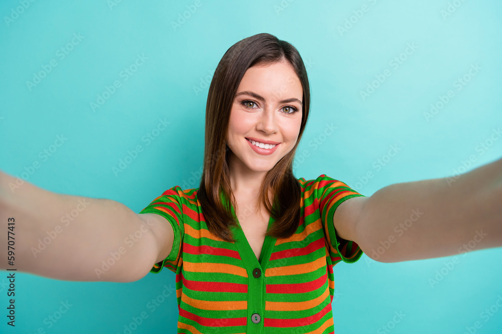 Photo of pretty adorable lady wear striped cardigan smiling recording video vlog isolated turquoise color background Photo of pretty adorable lady wear striped cardigan smiling recording video vlog isolated turquoise color background