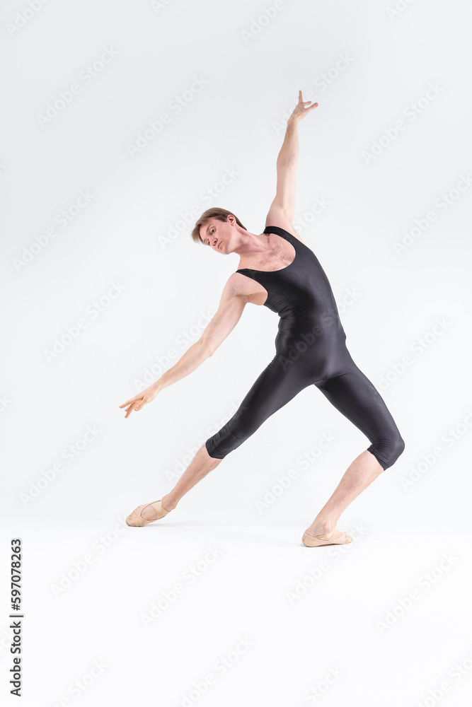 Professional Ballet Dancer Young Caucasian Athletic Man in Black Suit Posing Stretching in Studio On White