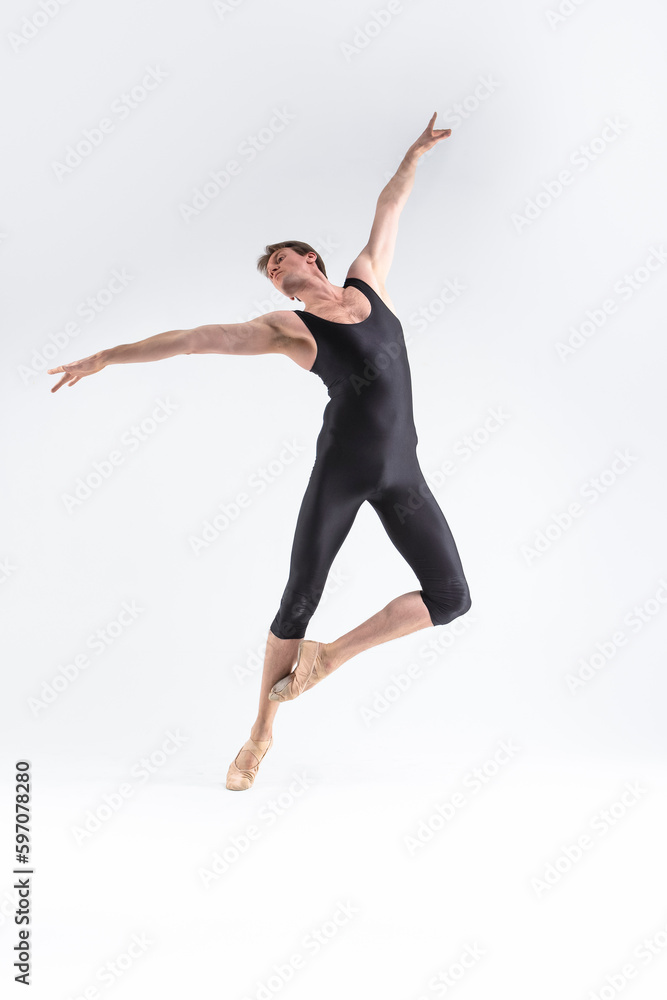 Ballet Dancer Young Athletic Man in Black Suit Posing in Stretching Pose Studio On White.