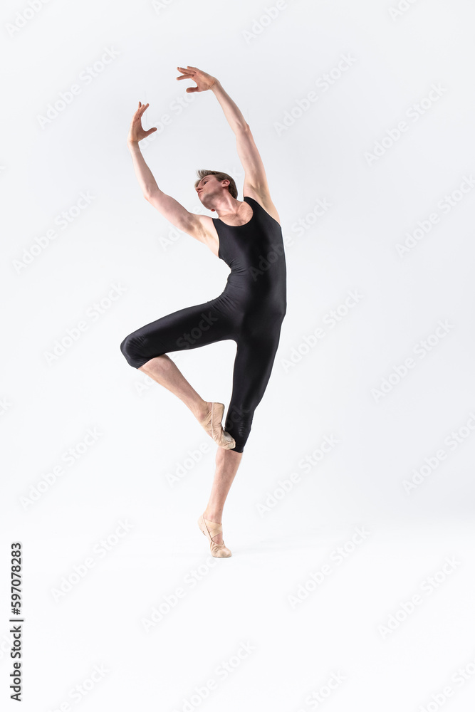 Obraz premium Professional Male Ballet Dancer Young Athletic Man in Black Suit Posing in Ballanced Stretching Dance Pose Studio On White.