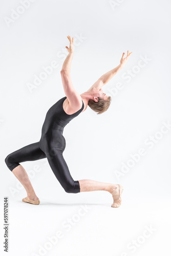 Professional Ballet Dancer Young Caucasian Athletic Man in Black Suit Posing in Studio On White With Lifted Hands.