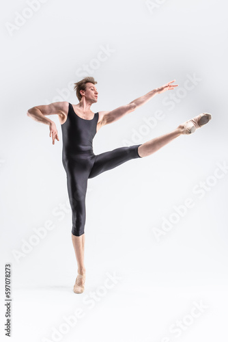 Professional Ballet Dancer Young Caucasian Athletic Man in Black Suit Posing Flying Dancing in Studio On White.
