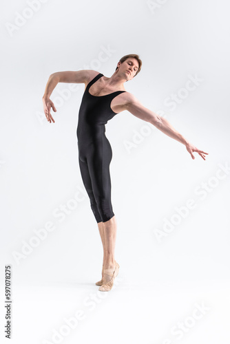 One Caucasian Ballet Dancer Young Athletic Man in Black Suit Posing in Studio On White. Vertical image