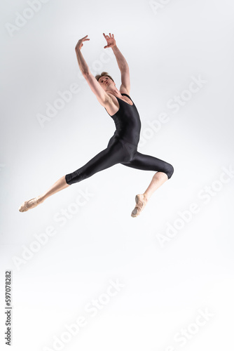 Caucasian Ballet Dancer Young Athletic Man in Black Suit Posing Dancing in Studio On White.