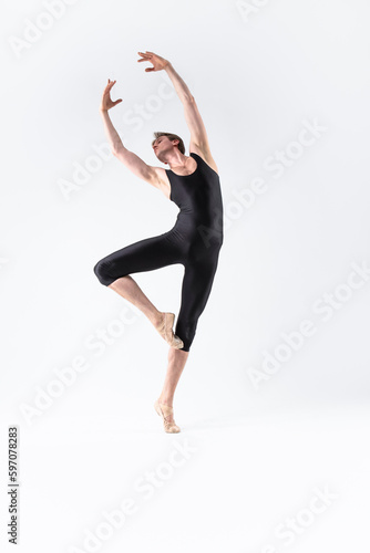 Professional Male Ballet Dancer Young Athletic Man in Black Suit Posing in Ballanced Stretching Dance Pose Studio On White.