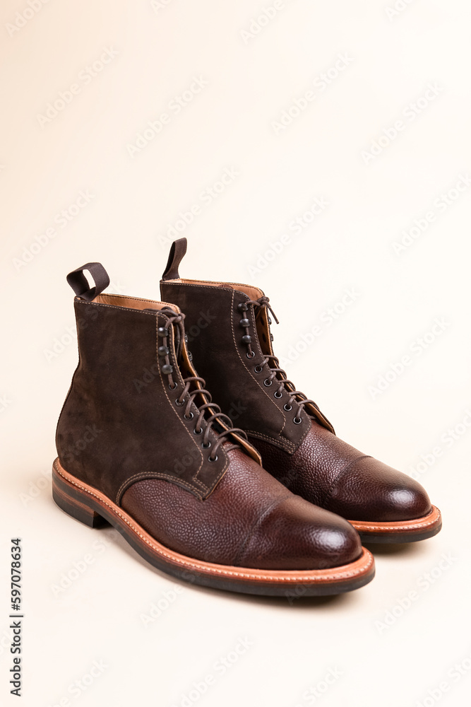 Pair of Premium Dark Brown Grain Brogue Derby Boots Made of Calf Leather with Rubber Sole Placed Over Beige Background.
