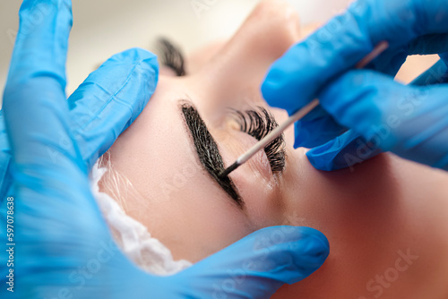 Tattoo Ideas. Beautician Tattooing Woman's Eyebrows Using Special Equipment During Process of Permanent Make-up. photo