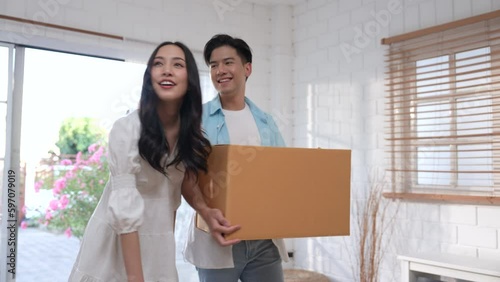 Happy Asian couple moving into their new home.