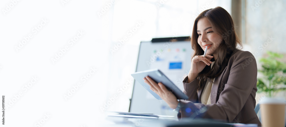 businesswoman in a black suit inside the office using tablet computer, audit paperwork for customers to contact, business people concept. businesswoman in a black suit inside the office using tablet computer, audit paperwork for customers to contact, business people concept.