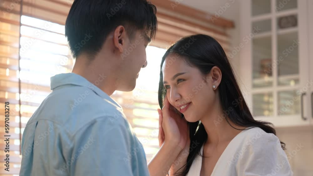 Happy young asian couple hugging while standing in the kitchen at home. Happy young asian couple hugging while standing in the kitchen at home.