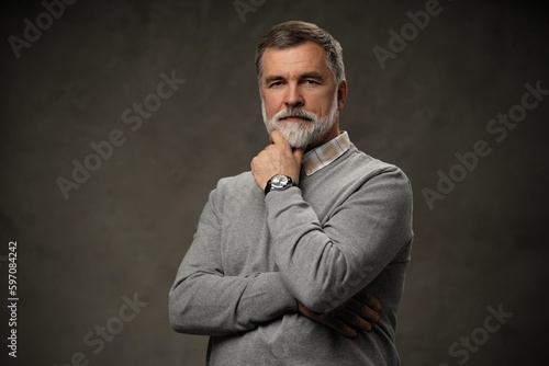 Portrait of happy casual mature man smiling, senior age man with gray hair, Isolated on dark gray background