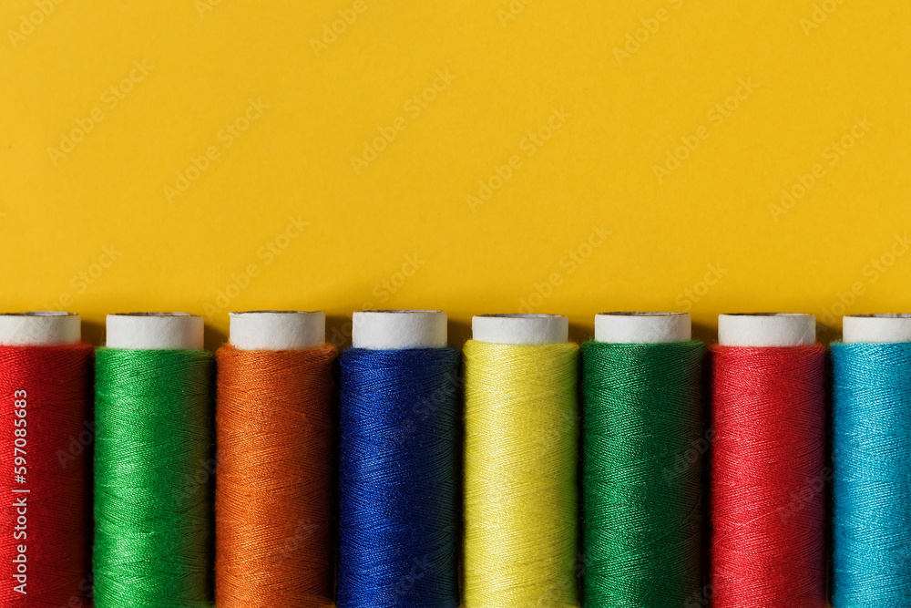 Set of colorful sewing treads on a yellow background. Top view. Copy space. Set of colorful sewing treads on a yellow background. Top view. Copy space.