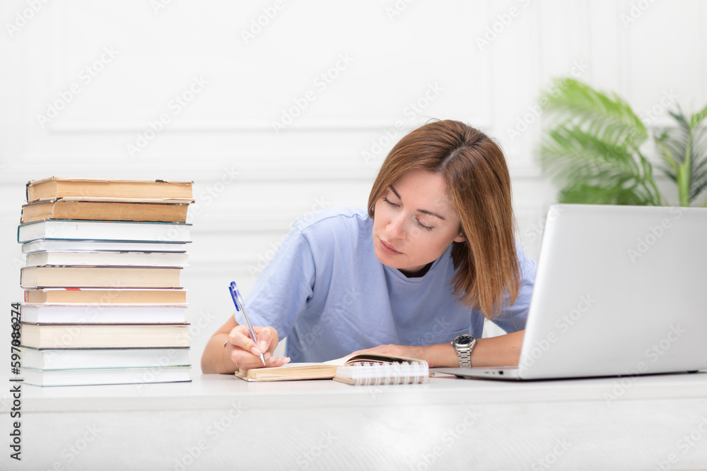Young attractive woman learning her lessons online at home. Distance education concept Young attractive woman learning her lessons online at home. Distance education concept