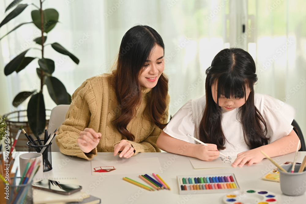 Image of mother and daughter drawing together in bright living room. Family home leisure concept Image of mother and daughter drawing together in bright living room. Family home leisure concept