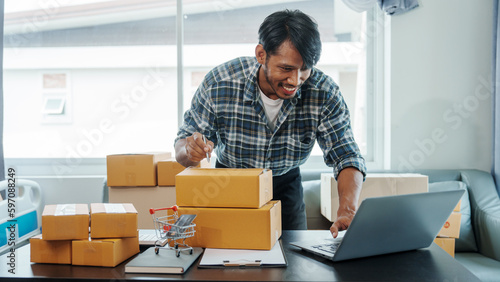 Mixed race Asian indian ethnicity young man chinese transport shipment delivery service sme parcel cardboard box package on delivery small business owner SME, shopping online © NanSan
