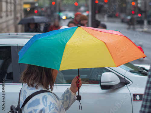 Personne avec un parapluie ouvert sous la pluie dans la rue 