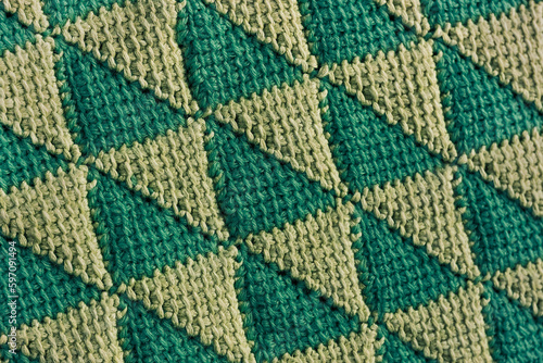 Green yellow crochet tunisian triangle shaped pattern. Knitted background.