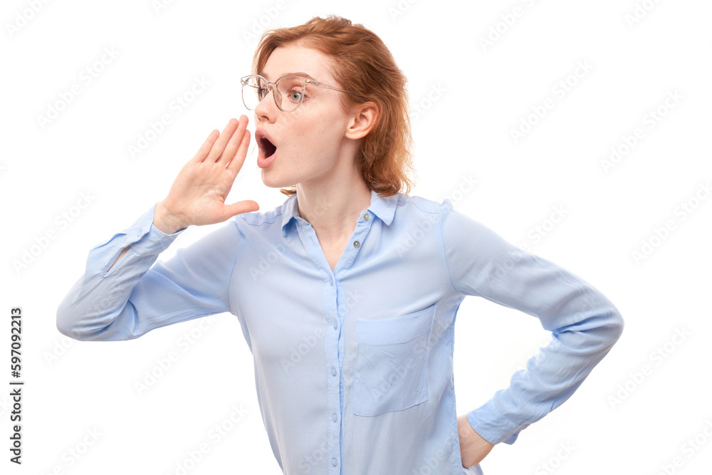 Portrait of redhead young woman screaming into her palms on white studio background. Important information, news concept Portrait of redhead young woman screaming into her palms on white studio background. Important information, news concept