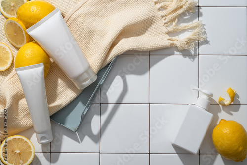 Obraz na plátně Over a mosaic tiles background, two white tubes and beige wool scarf are put on a tray, arranged with a pump bottle