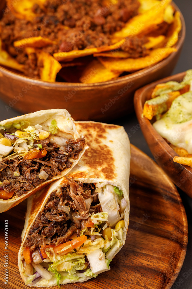 Burrito with pulled beef, nachos with chili con carne, french fries