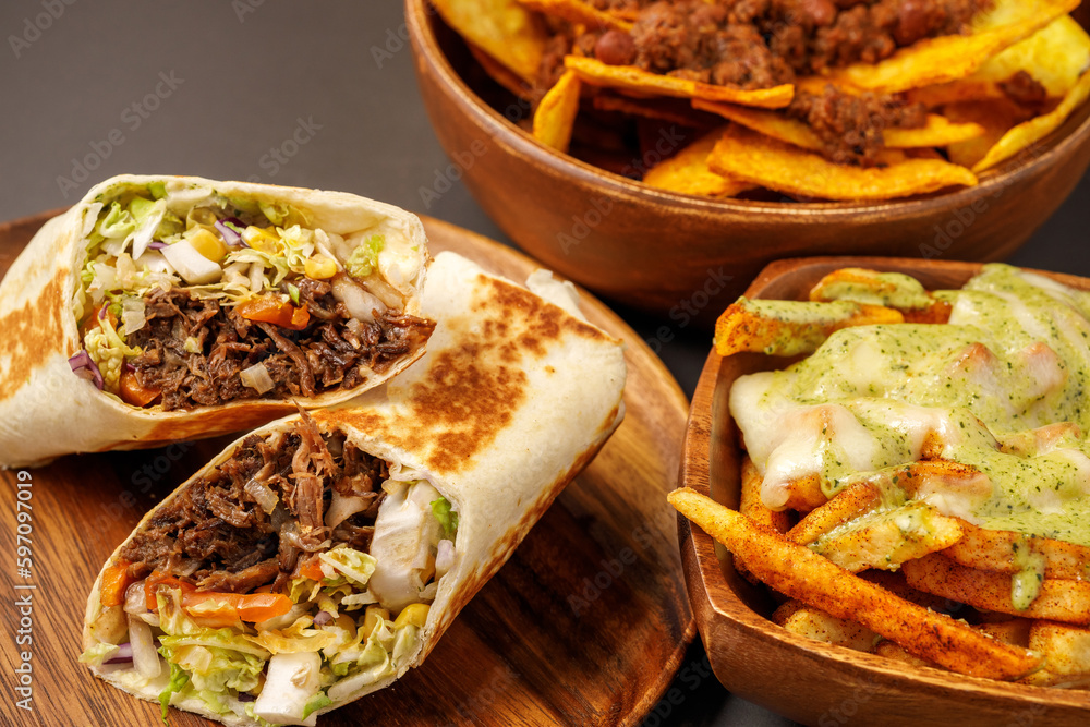Burrito with pulled beef, nachos with chili con carne, french fries